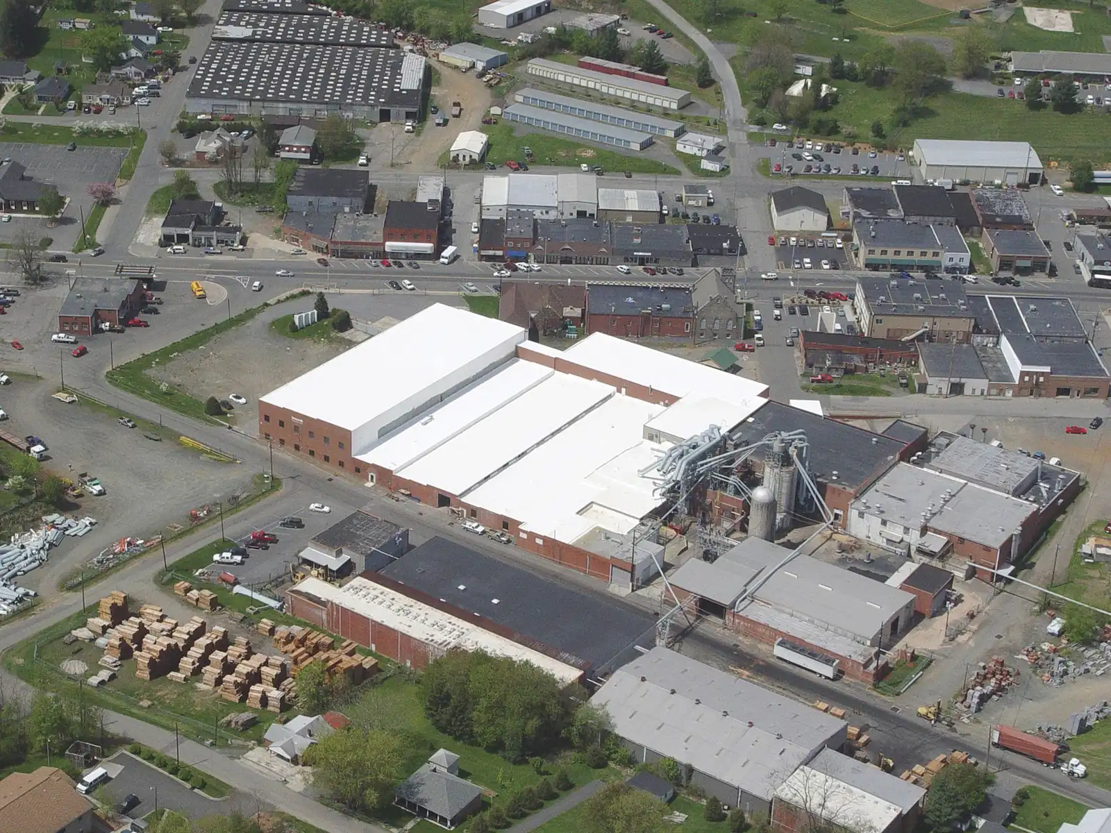 Aerial view of an industrial district with white commercial roofs
