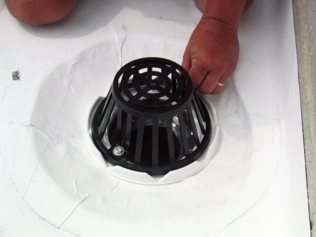 Roof drain sealed and detailed in a white coating system