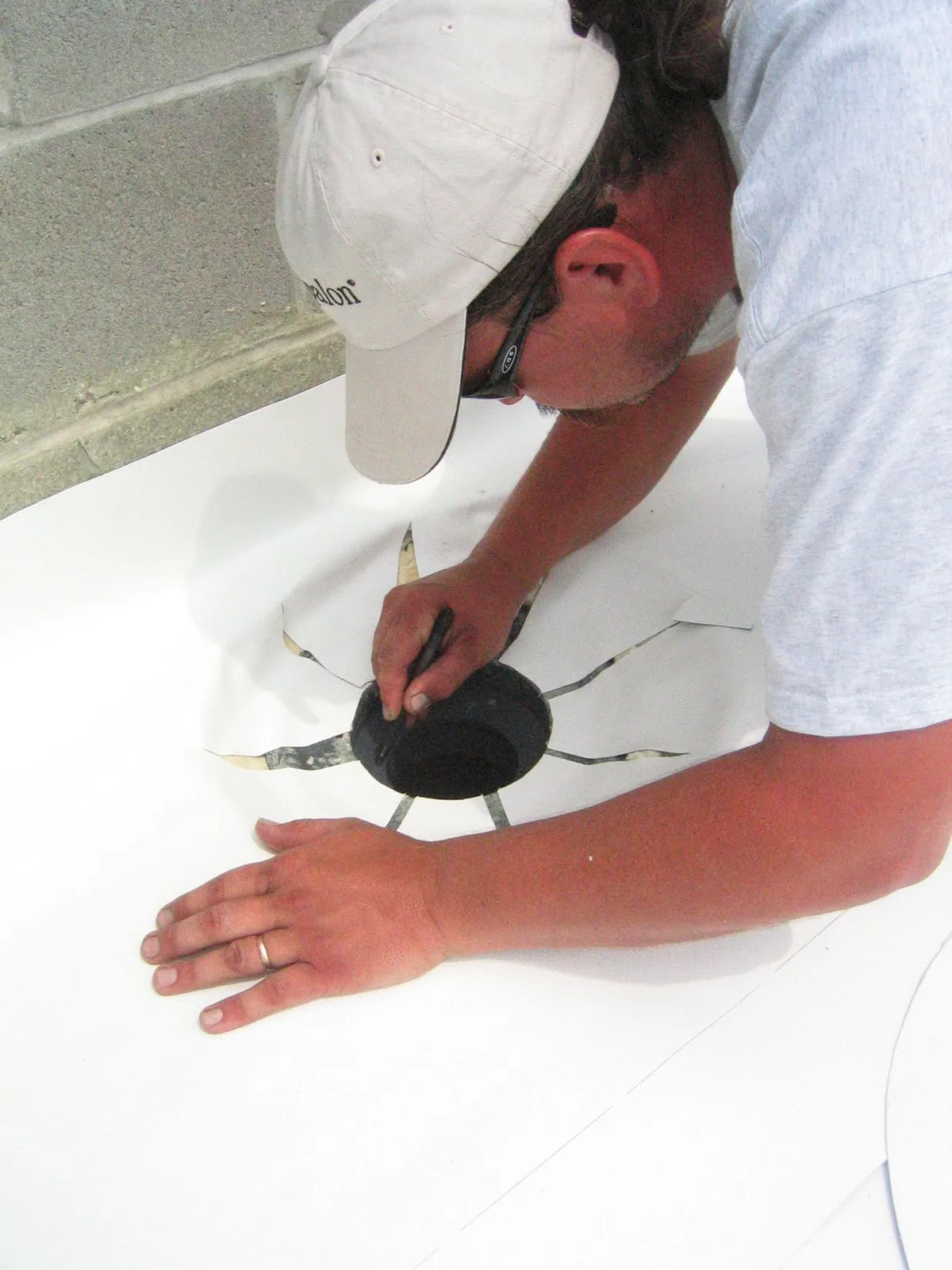 Roofer sealing a roof penetration with fabric and base coat